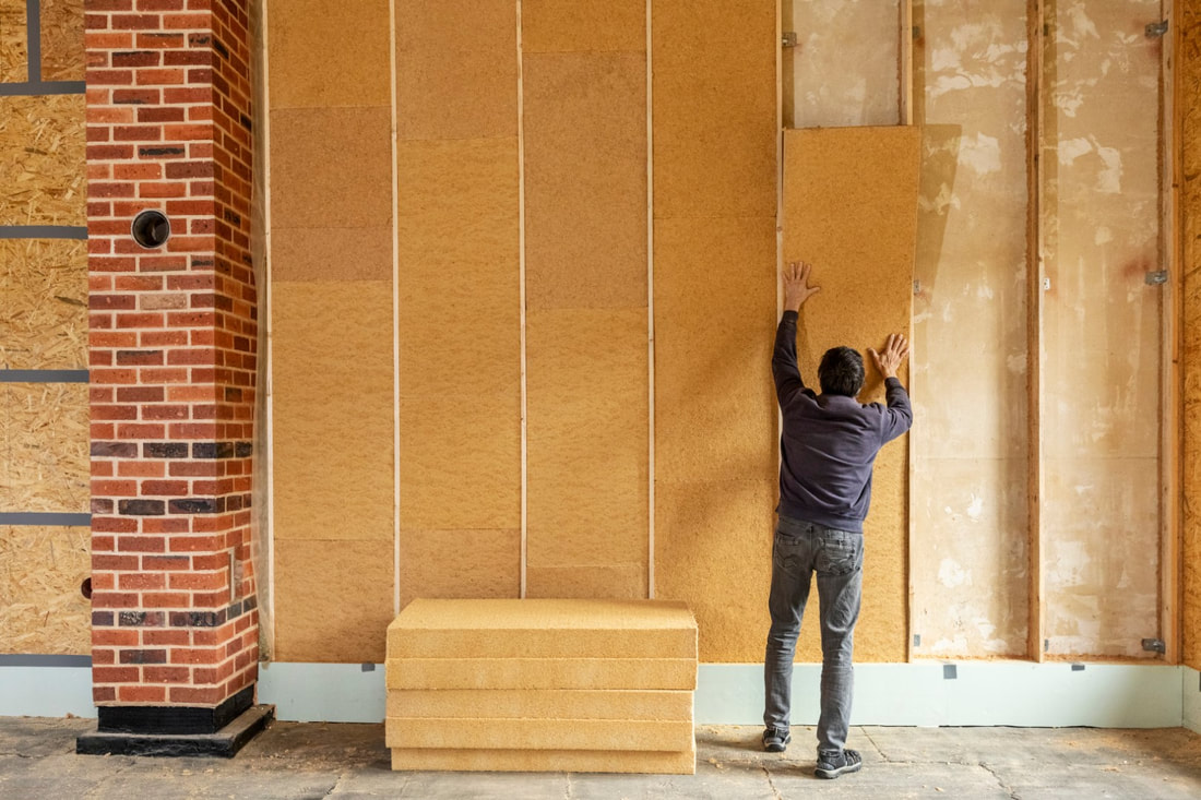 man installing building insulation in walls
